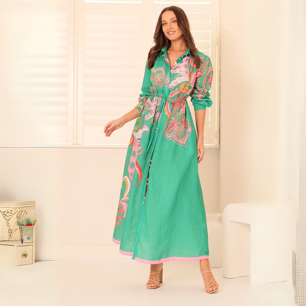 Our La Palma Dress has a bold green base with a multi coloured floral and paisley print. It features a collar, long sleeves and a maxi length skirt.