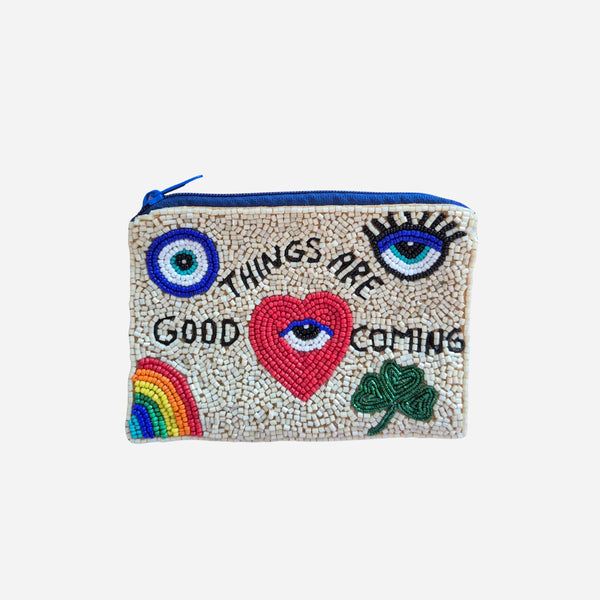 Beaded Good Things Are Coming Pouch. This compact pouch has a zip top closure and colourful symbols on the front (eye, clover, heart, rainbow).