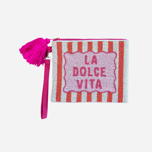Striped beaded pouch with 'La Dolce Vita' on the front with white and orange stripes. It also has a pink tassel and pink fabric wrist strap.